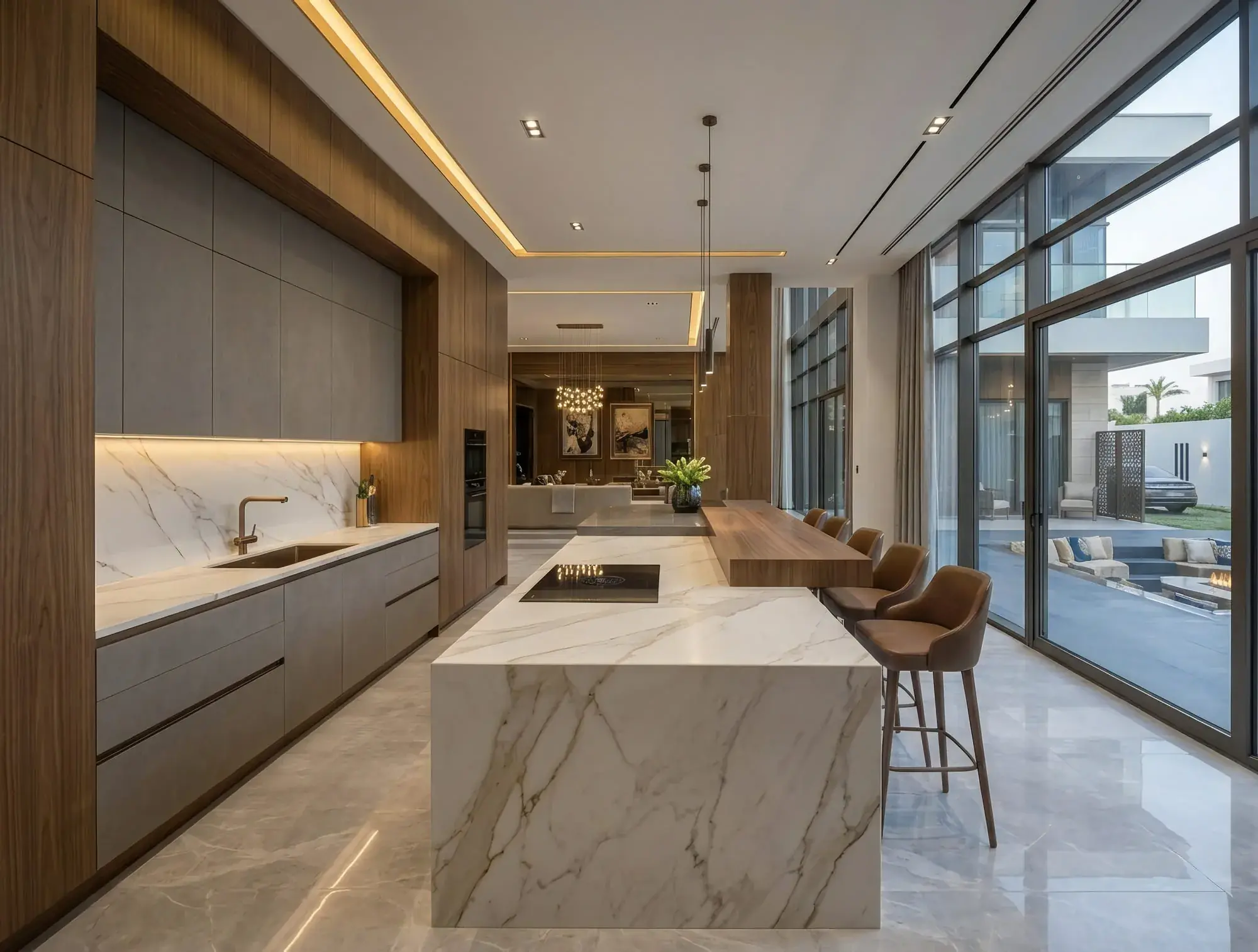 The kitchen: a monolithic marble waterfall island with an integrated hob, a walnut dining counter running off its end, and full-height walnut and stone millwork along the wall behind.